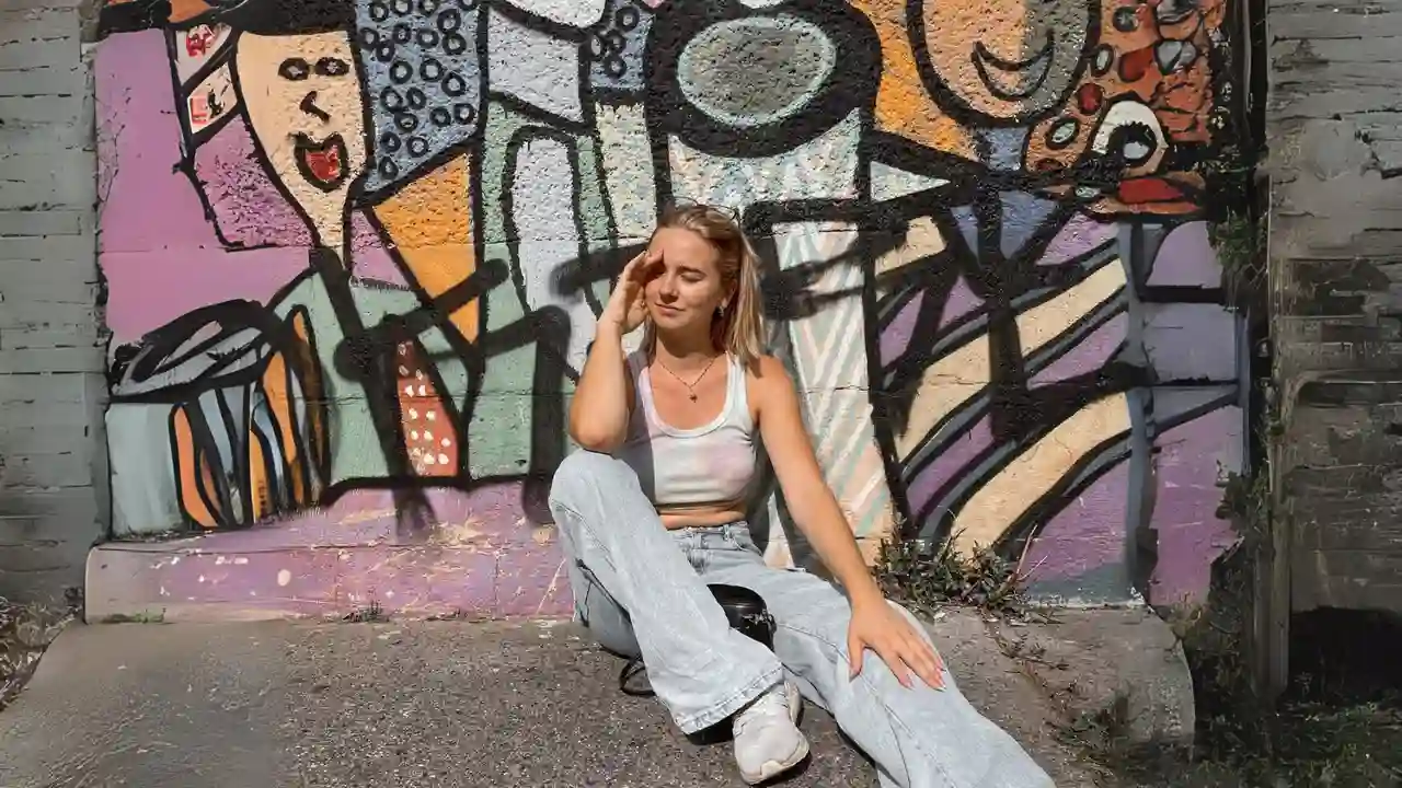 Foto von Joelle vom TikTok Account heutemaljoelle mit einem Portait. Im Hintergrund eine Wand mit Graffiti